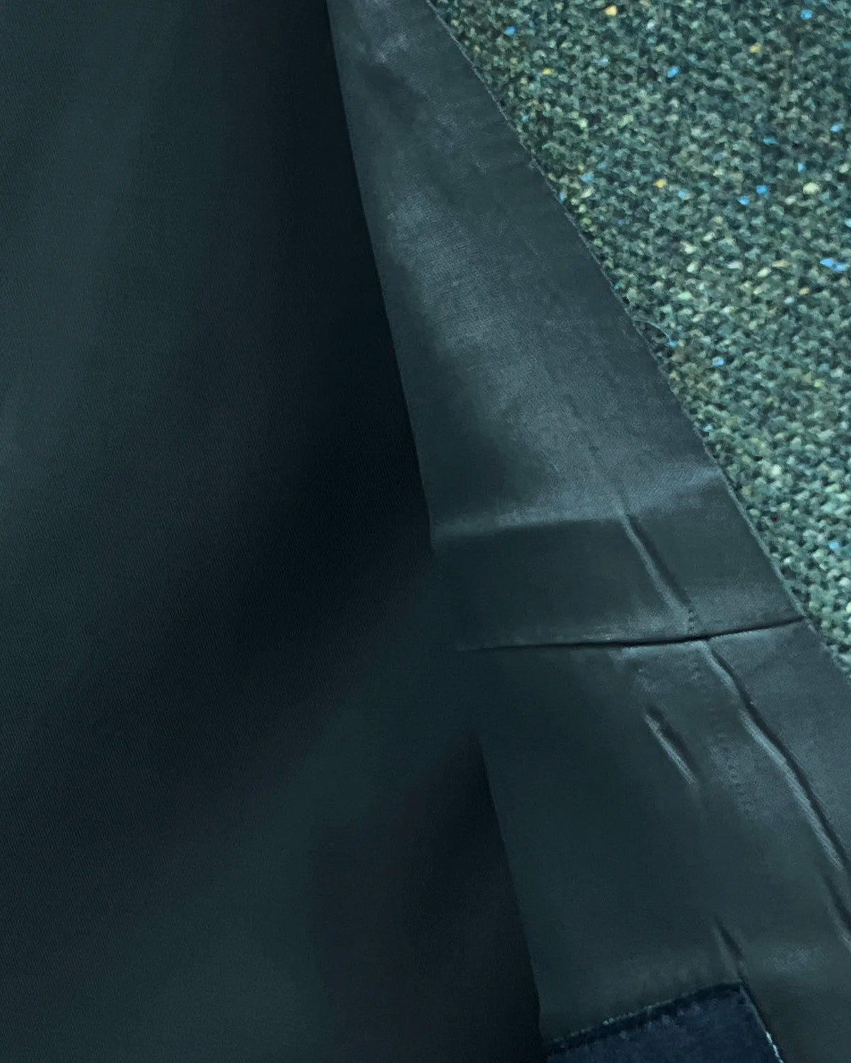 Interior detail of dark forest green Donegal tweed men's suit showing the dark silky lining