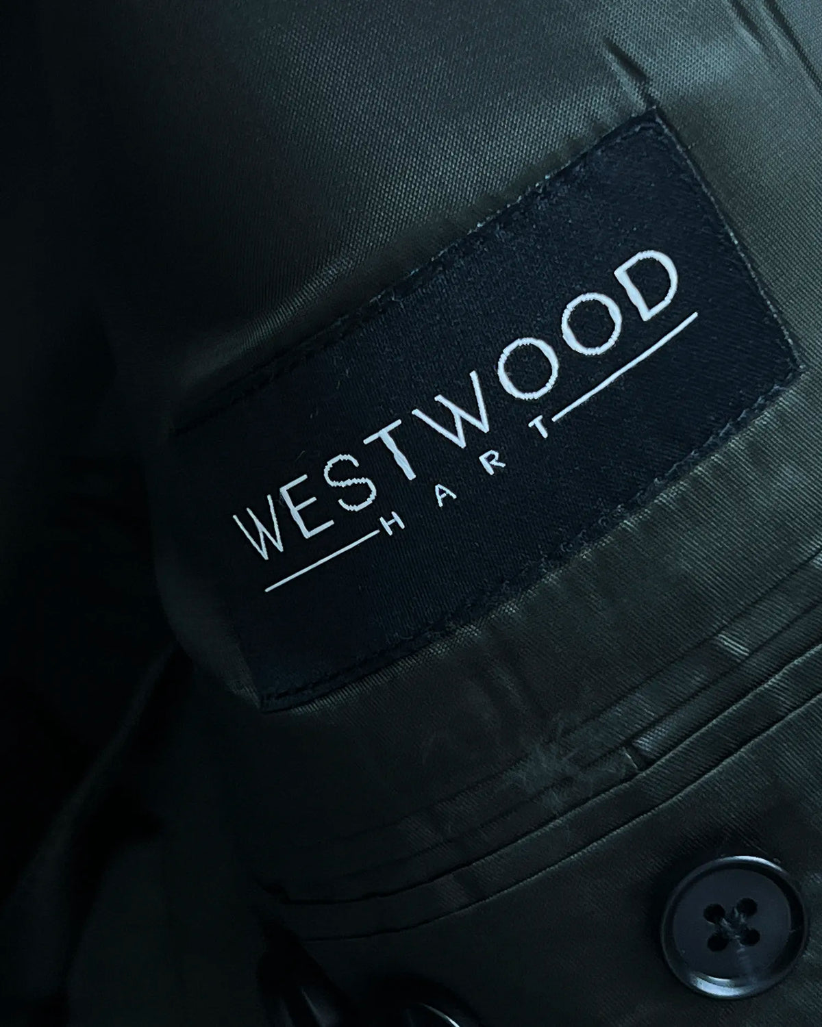 Mill label detail of dark forest green Donegal tweed men's suit showing the fabric identification