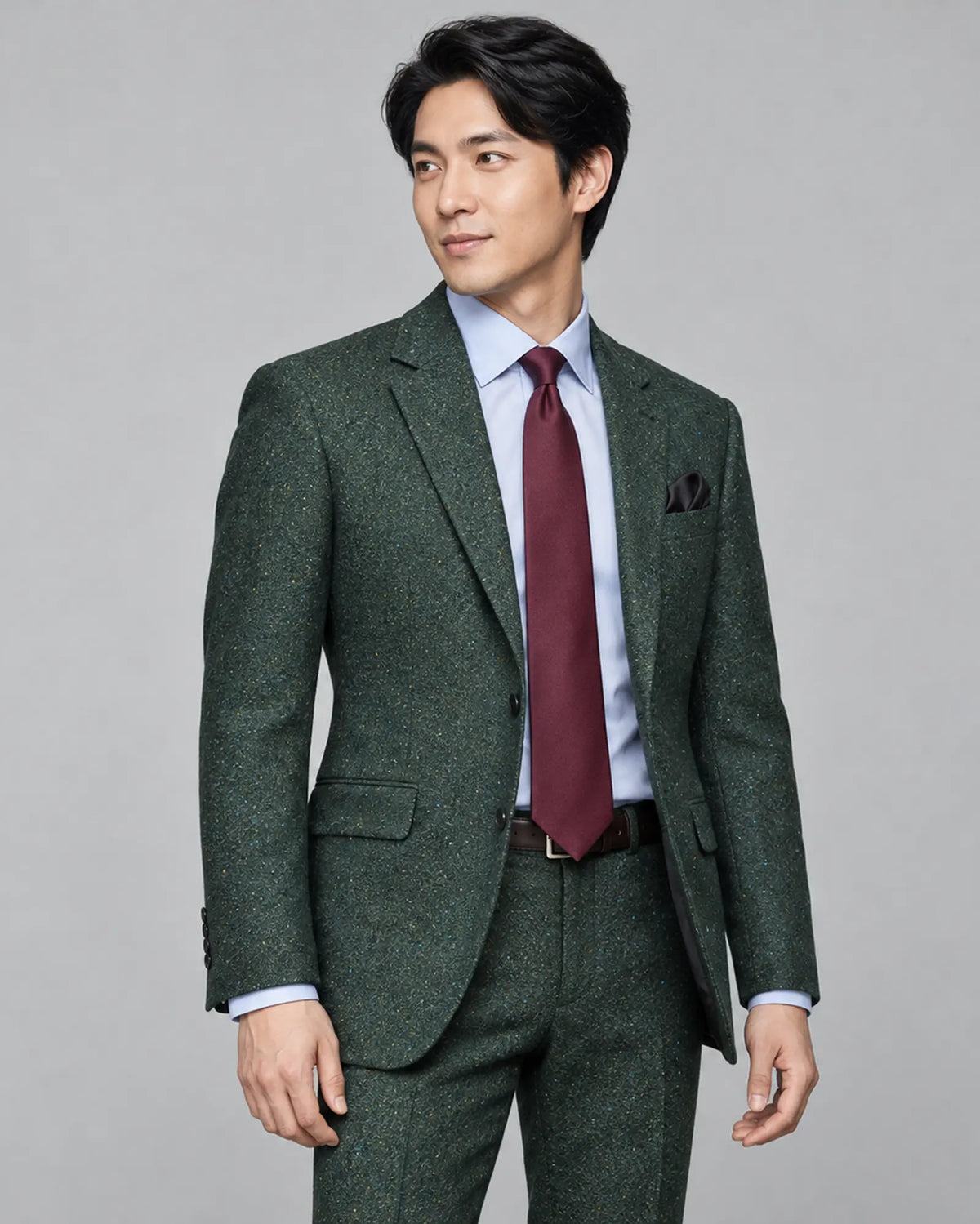 Three quarter view of dark forest green Donegal tweed men's suit showing the jacket shape and trouser coordination