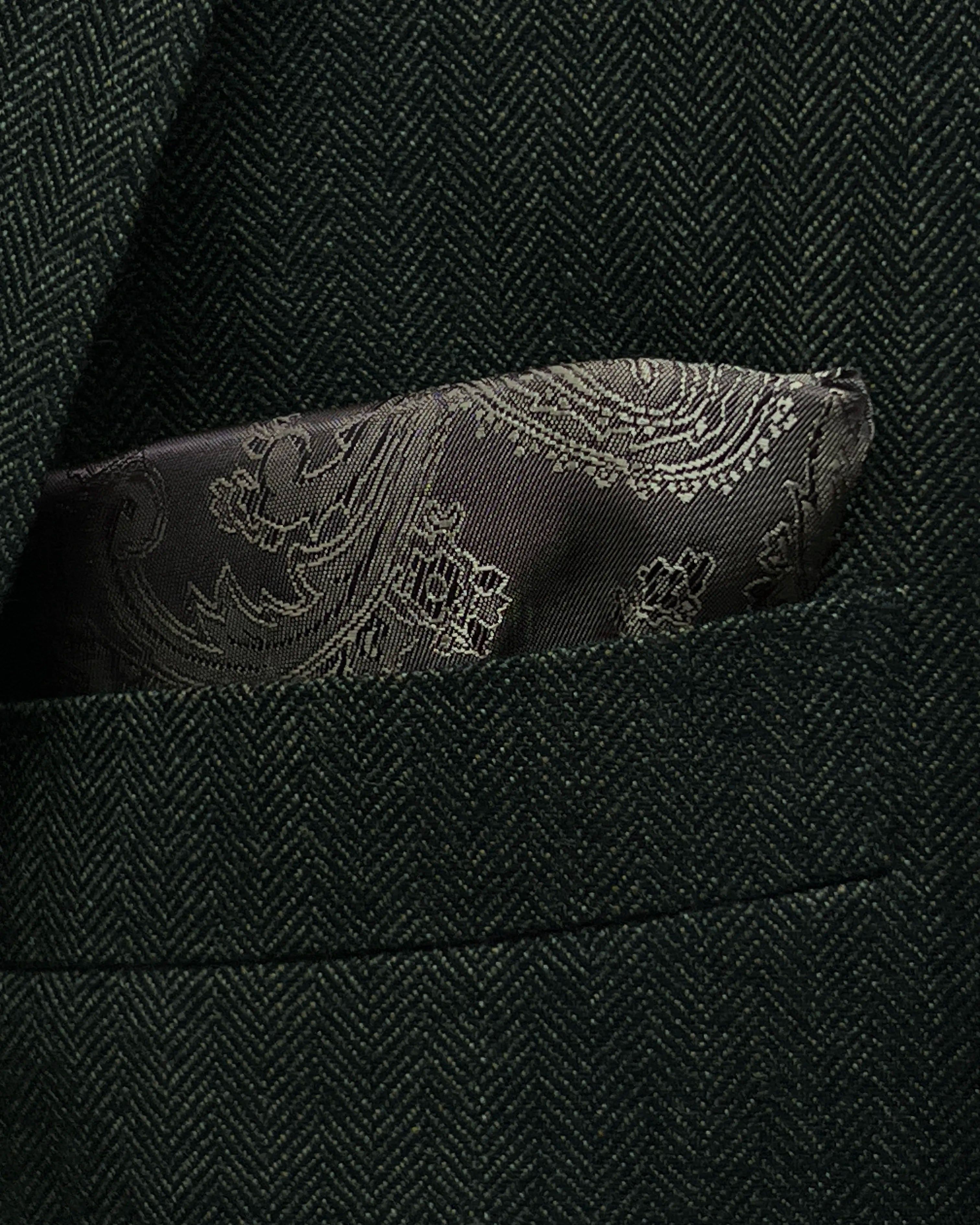 Pocket square detail of dark forest green herringbone men's suit showing built in lining pocket square