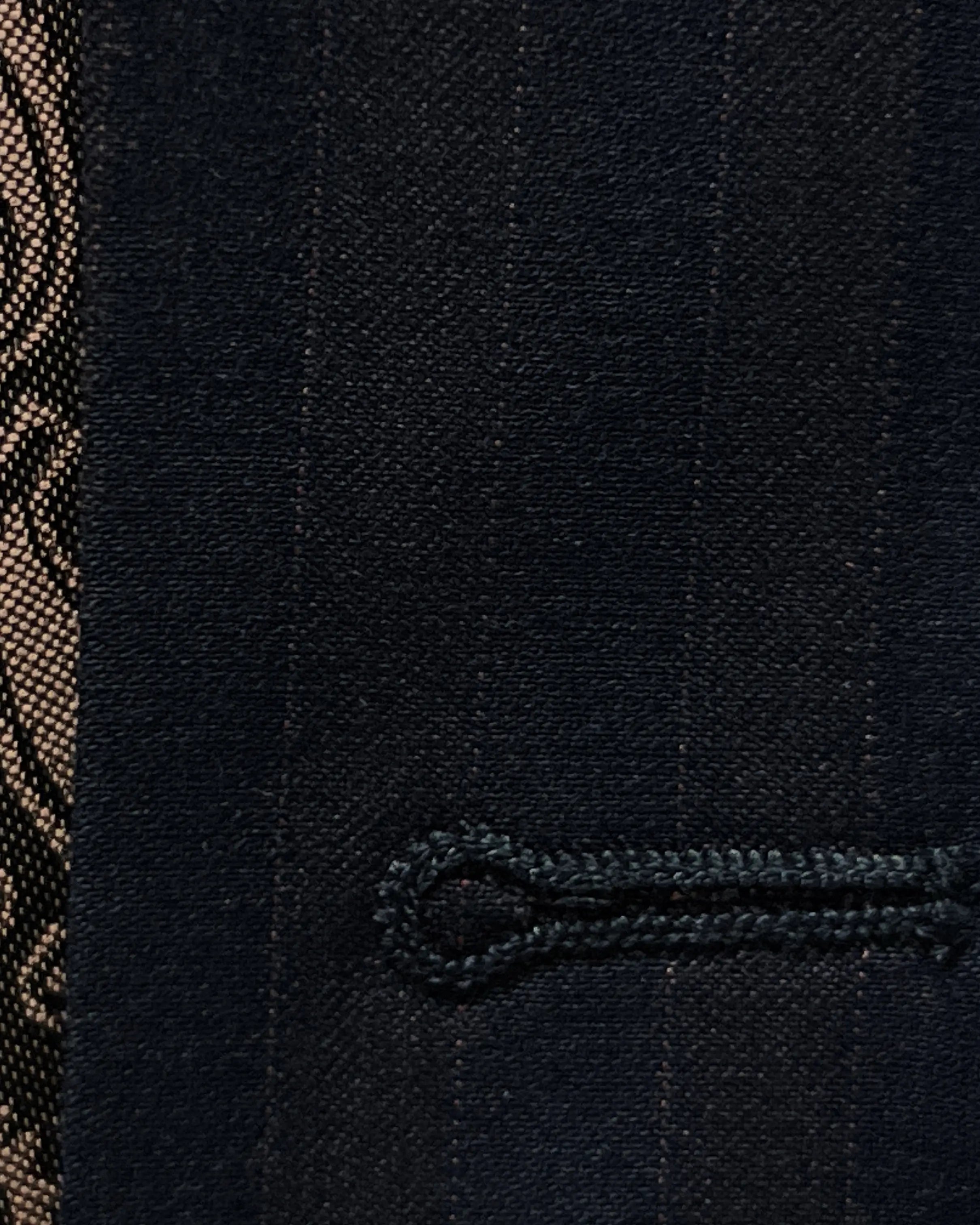 Buttonhole detail of dark navy with brown herringbone stripe men's suit showing the front buttonhole finish.