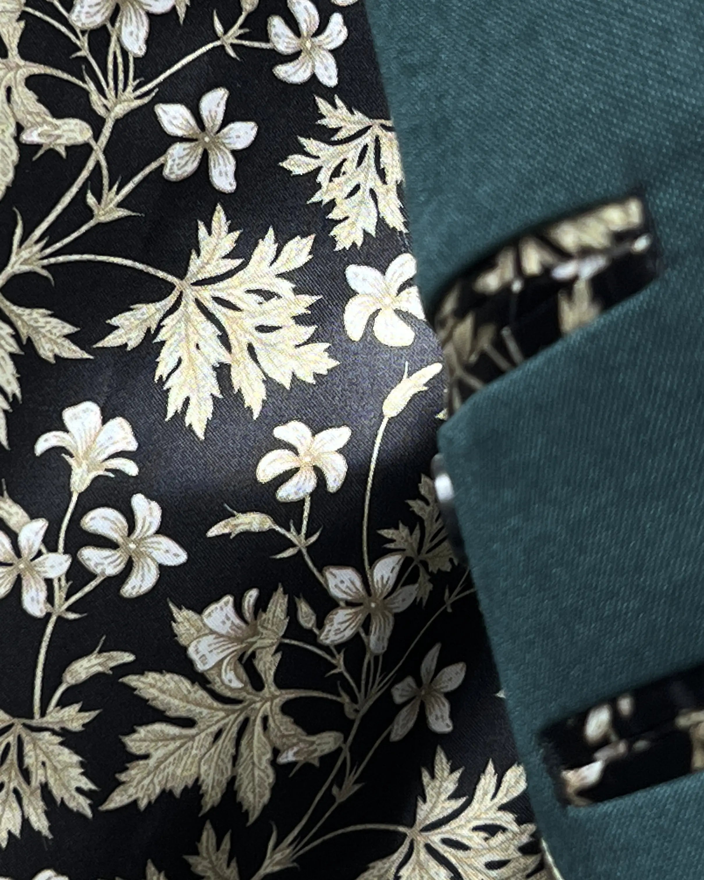 Lining detail of deep teal green solid men's suit showing black floral Bemberg silk lining