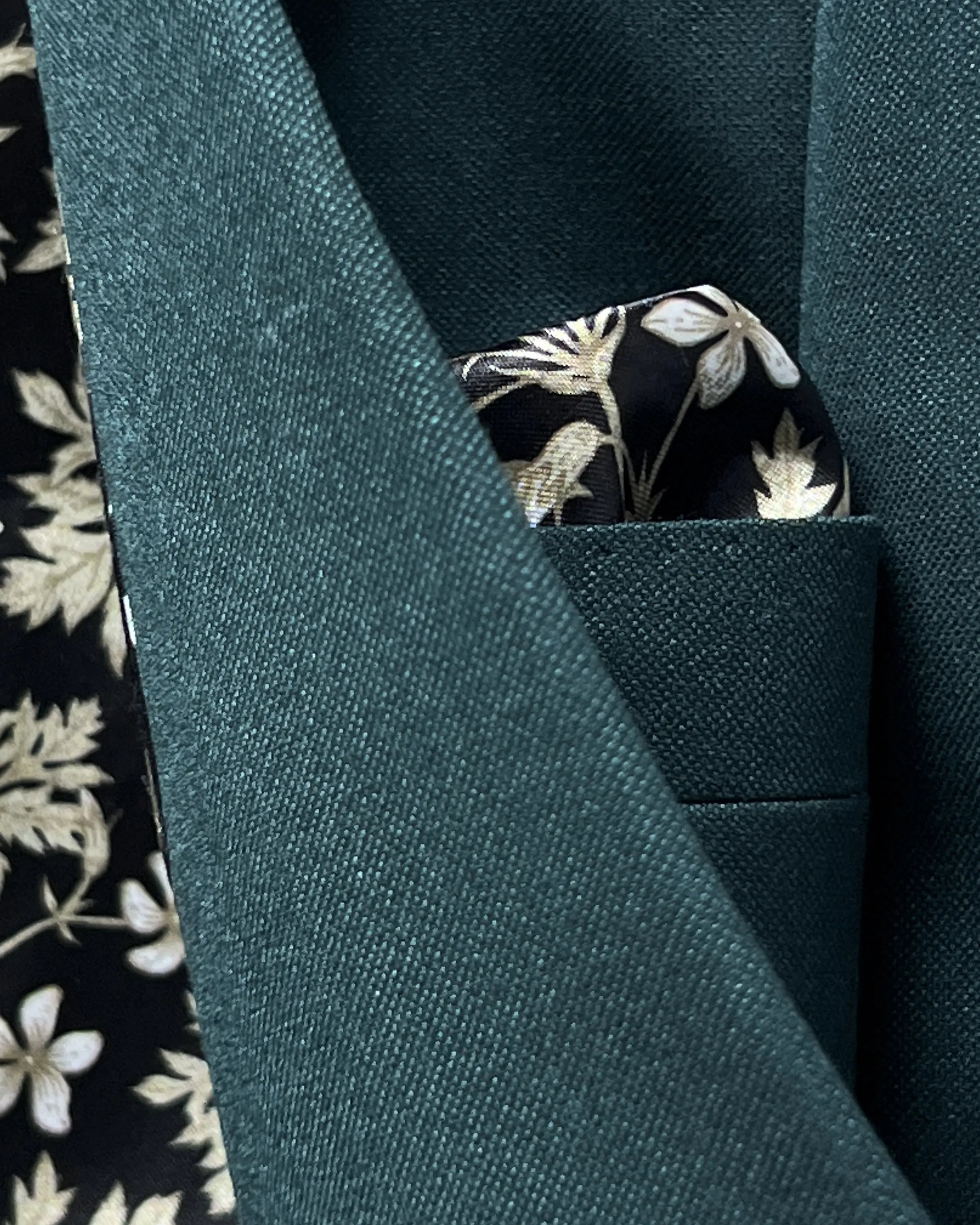 Fabric texture close up of deep teal green solid men's suit showing cloth surface, weave, and tailored wool finish