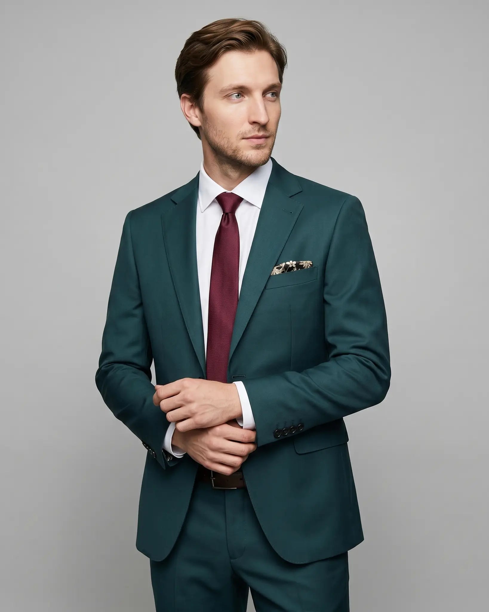Mid thigh model view of deep teal green solid men's suit showing lapel shape, jacket front, sleeve buttons, and subtle lining glimpse