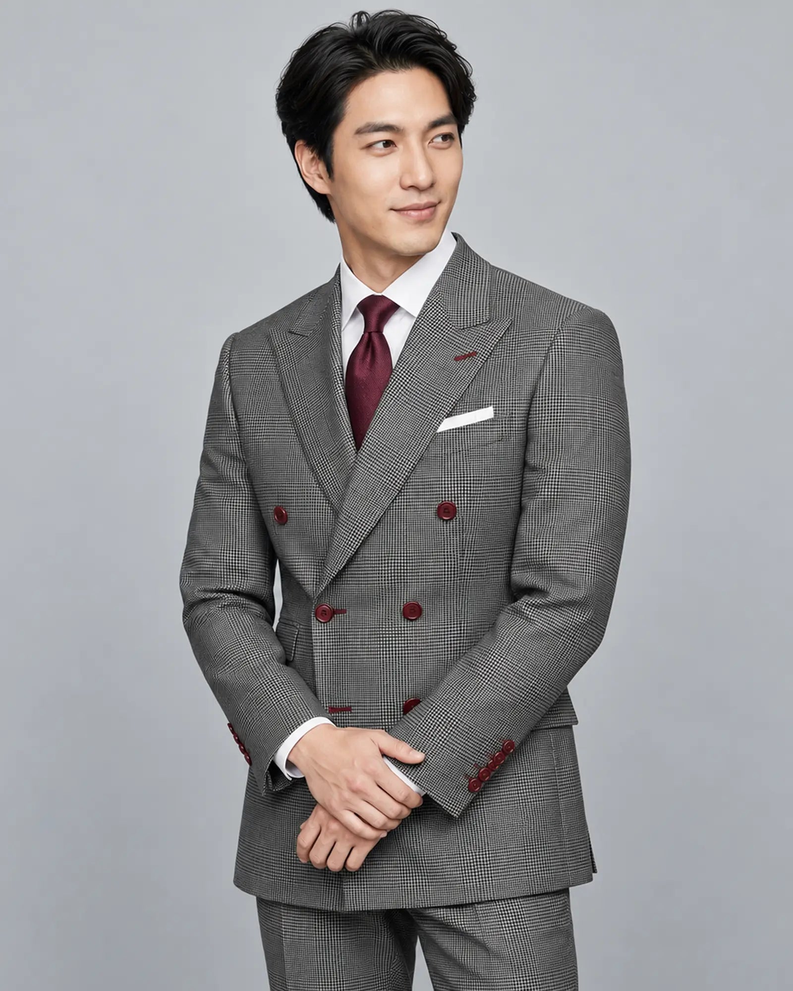 Mid thigh view of grey houndstooth Prince of Wales Glen plaid men's suit showing peak lapels and ticket pocket