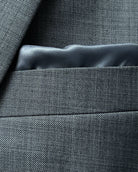 Breast pocket close up of grey sharkskin men's suit showing built in lining pocket square