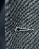 Buttonhole close up of grey sharkskin men's suit showing standard buttonhole stitching