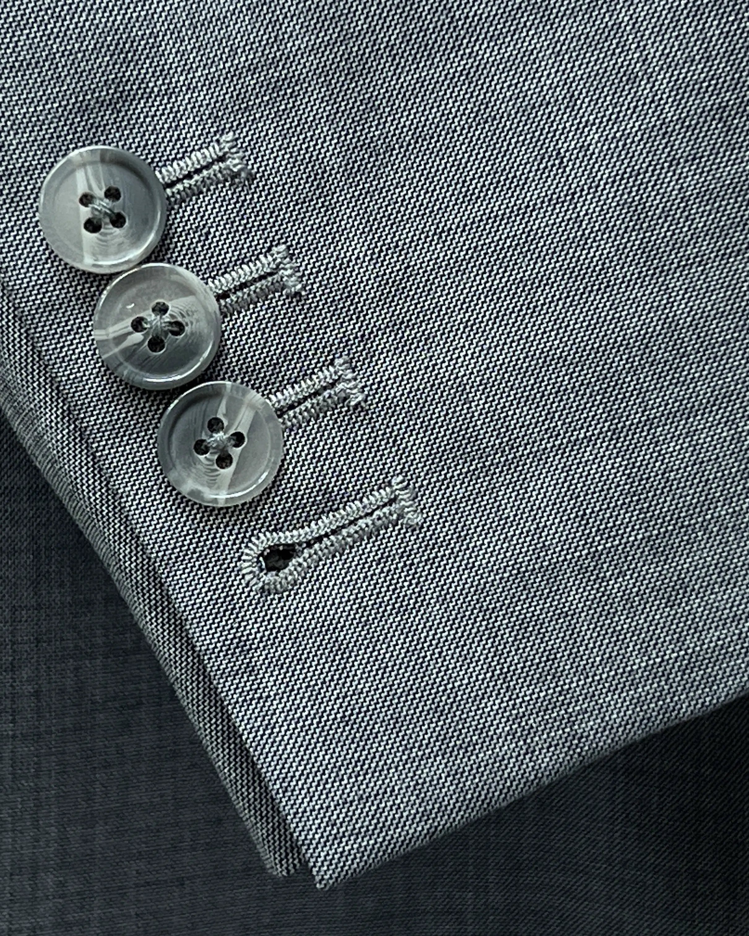Sleeve cuff close up of grey sharkskin men's suit showing functional sleeve buttons