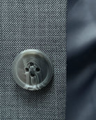 Button close up of grey sharkskin men's suit showing grey horn buttons