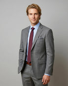 Side model view of grey sharkskin men's suit showing angled three quarter styling