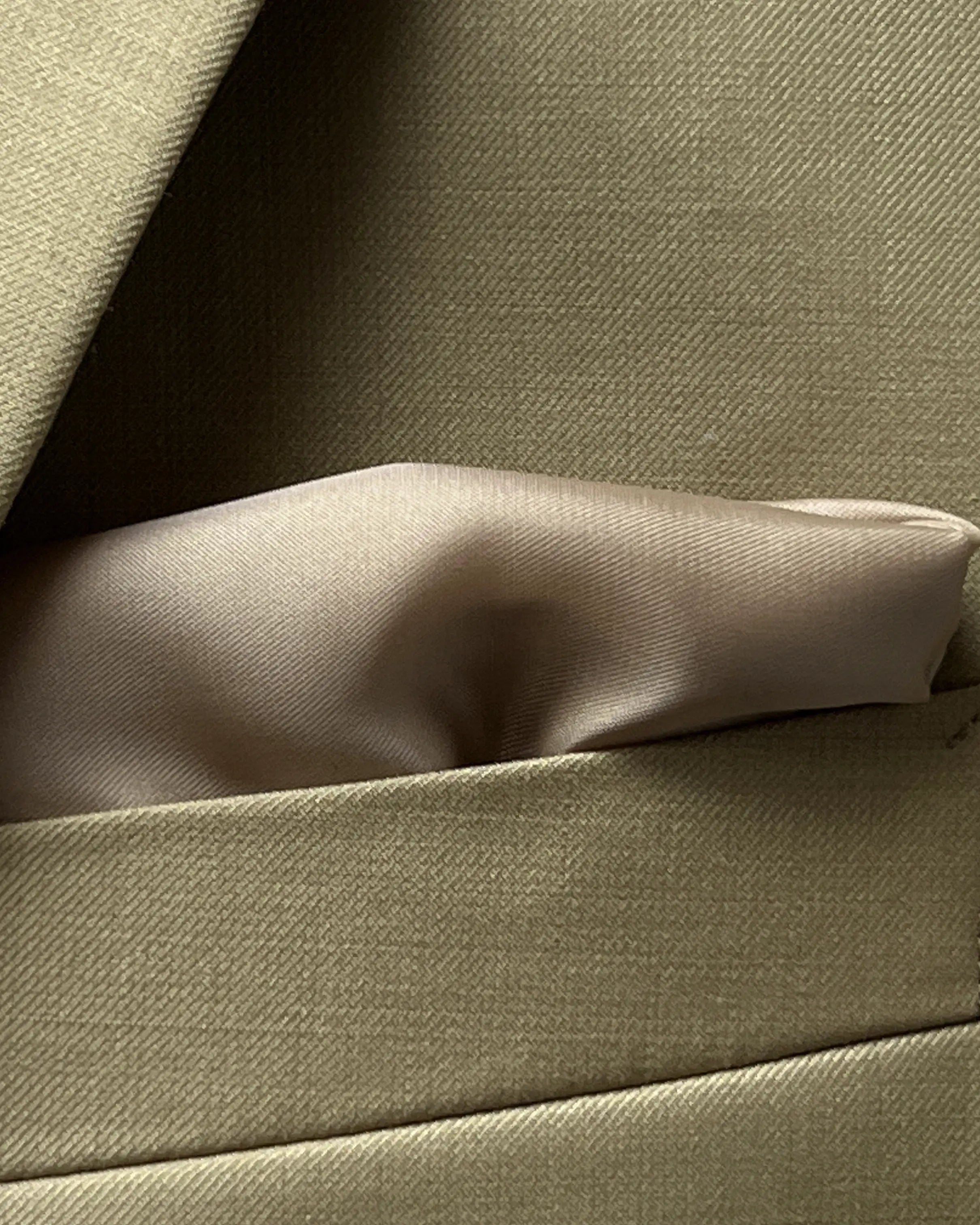 Pocket square view of brown plain men's suit showing built in matching lining pocket square