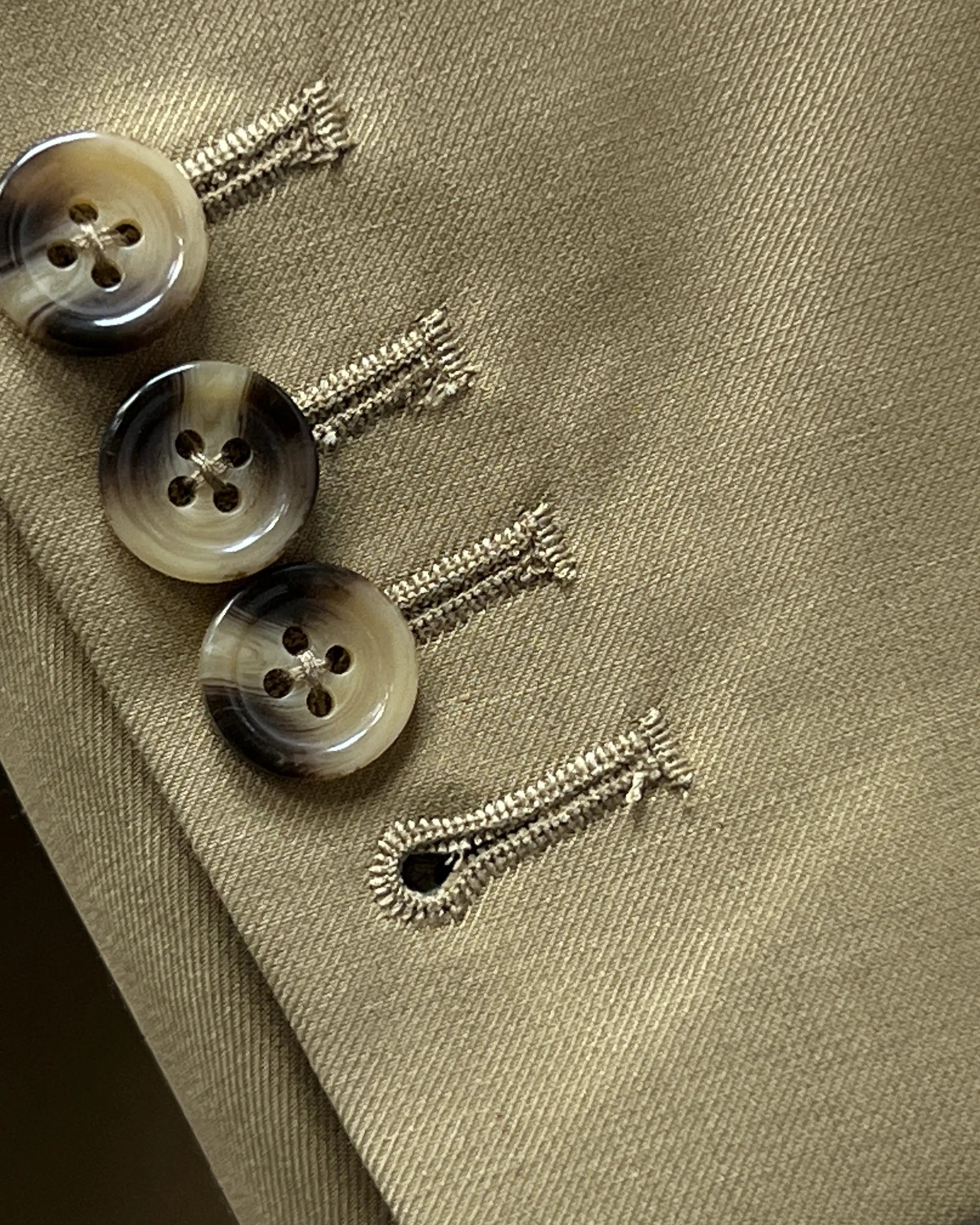 Sleeve cuff close up of brown plain men's suit showing functional sleeve buttons