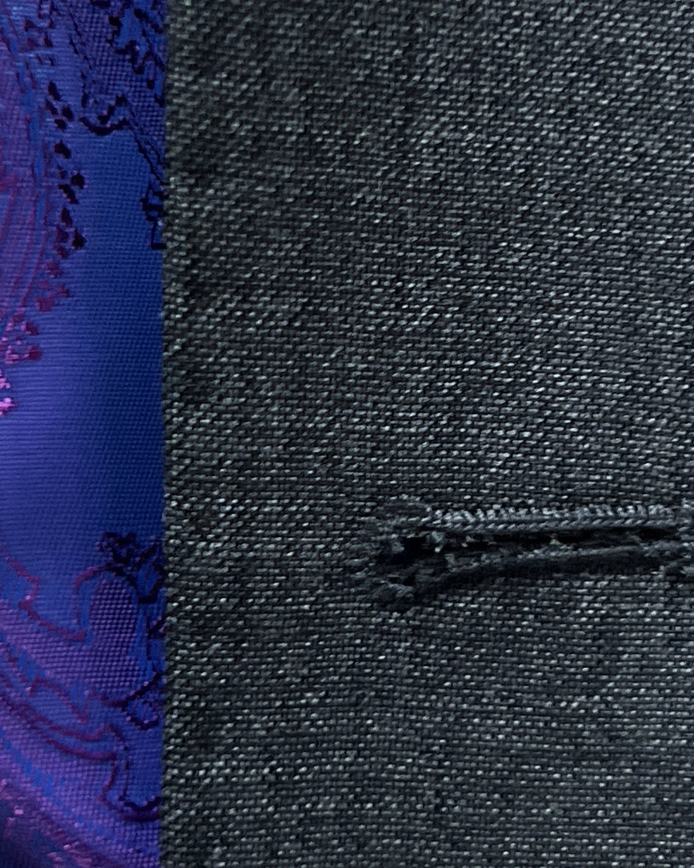 Buttonhole close up of medium grey sharkskin men's suit showing front buttonhole construction