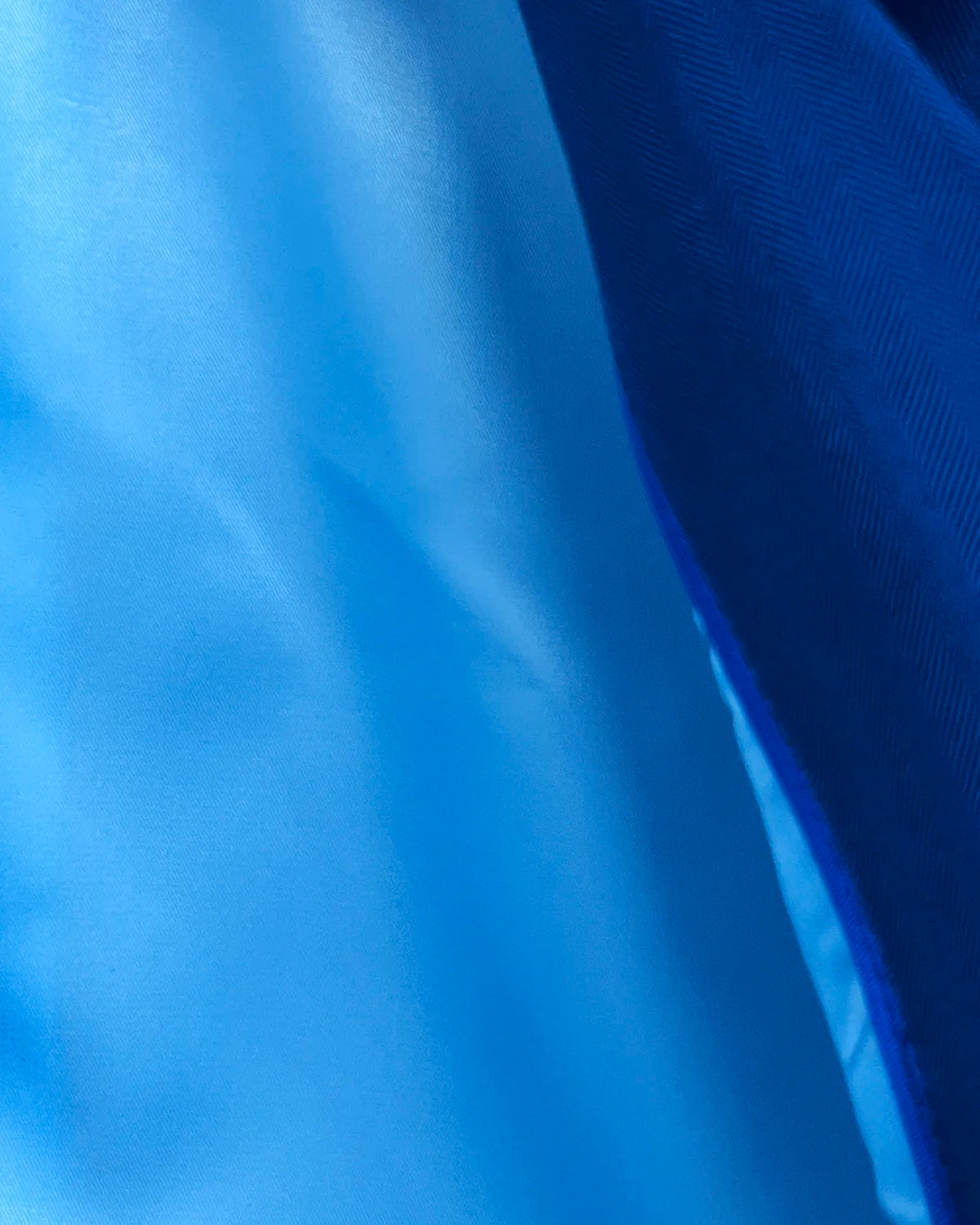 Interior detail of royal blue herringbone men's suit showing sky blue silk Bemberg lining