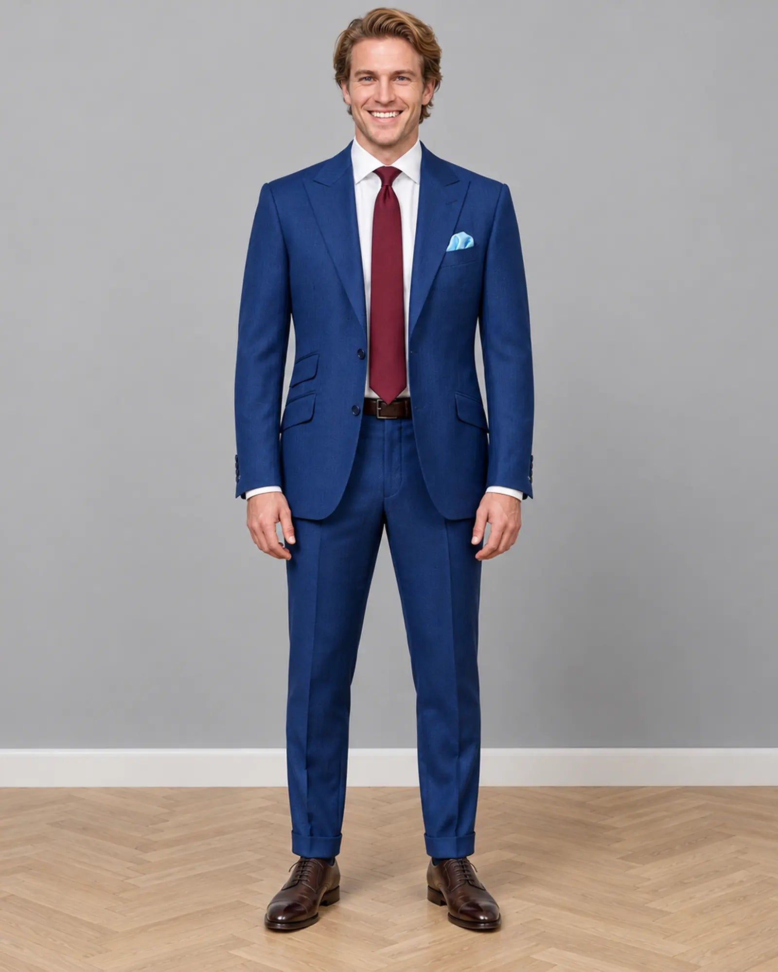 Full body front view of royal blue herringbone men's suit showing peak lapels and tailored silhouette