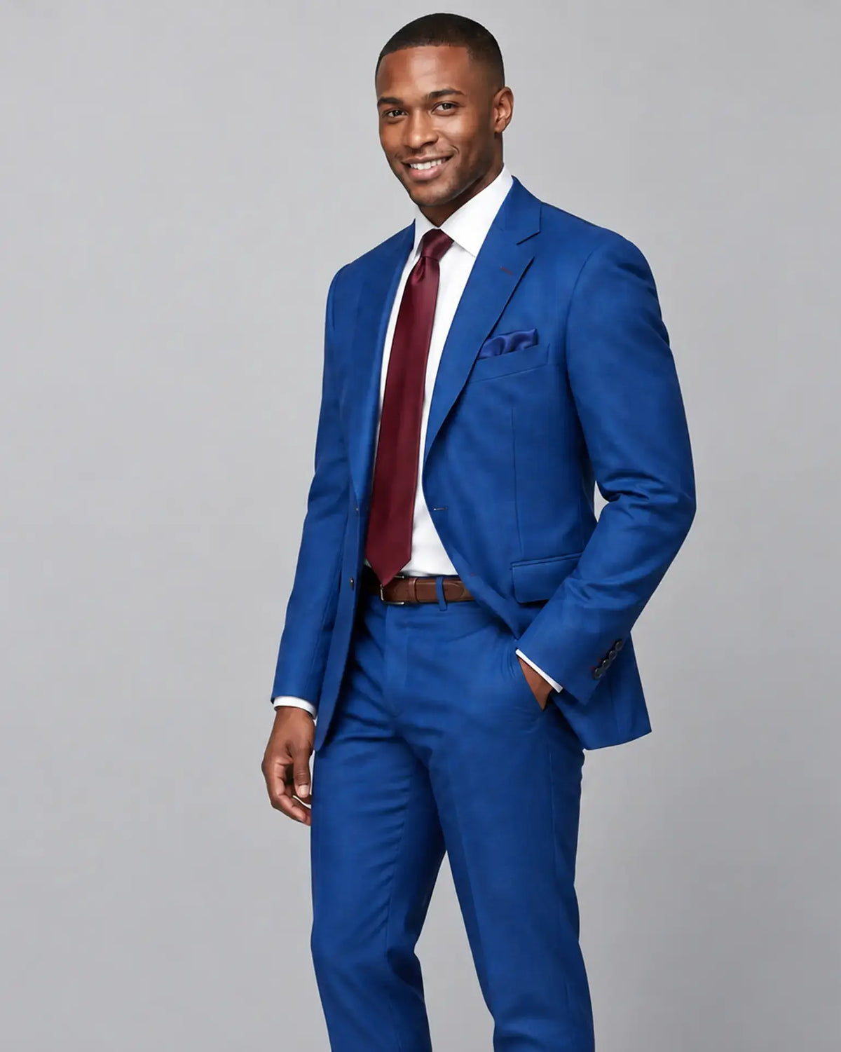 Three quarter view of royal blue Prince of Wales glen check with rust overcheck men's suit showing the jacket cut and fit