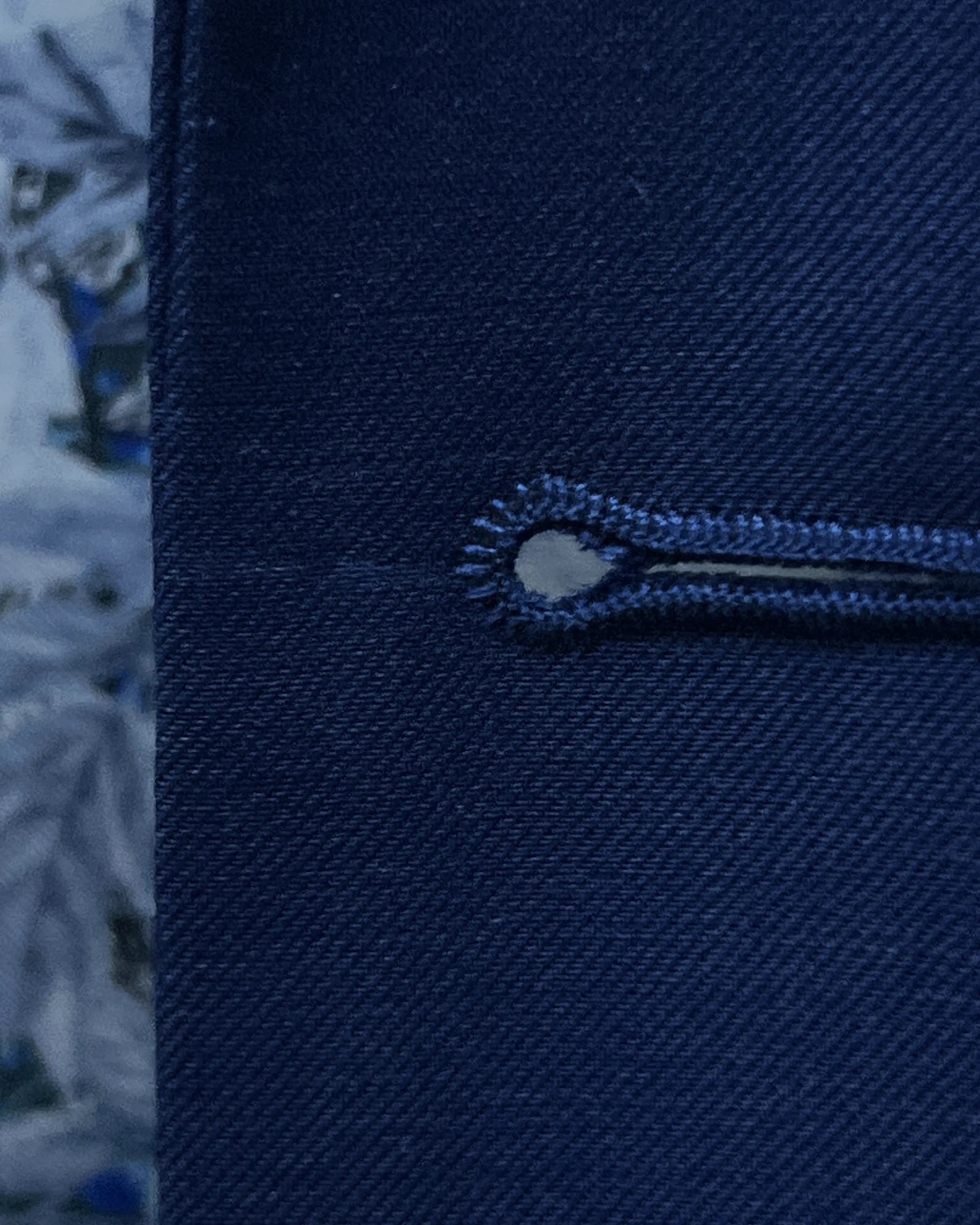 Front buttonhole close up of royal blue sharkskin men's suit showing clean tailored buttonhole construction.