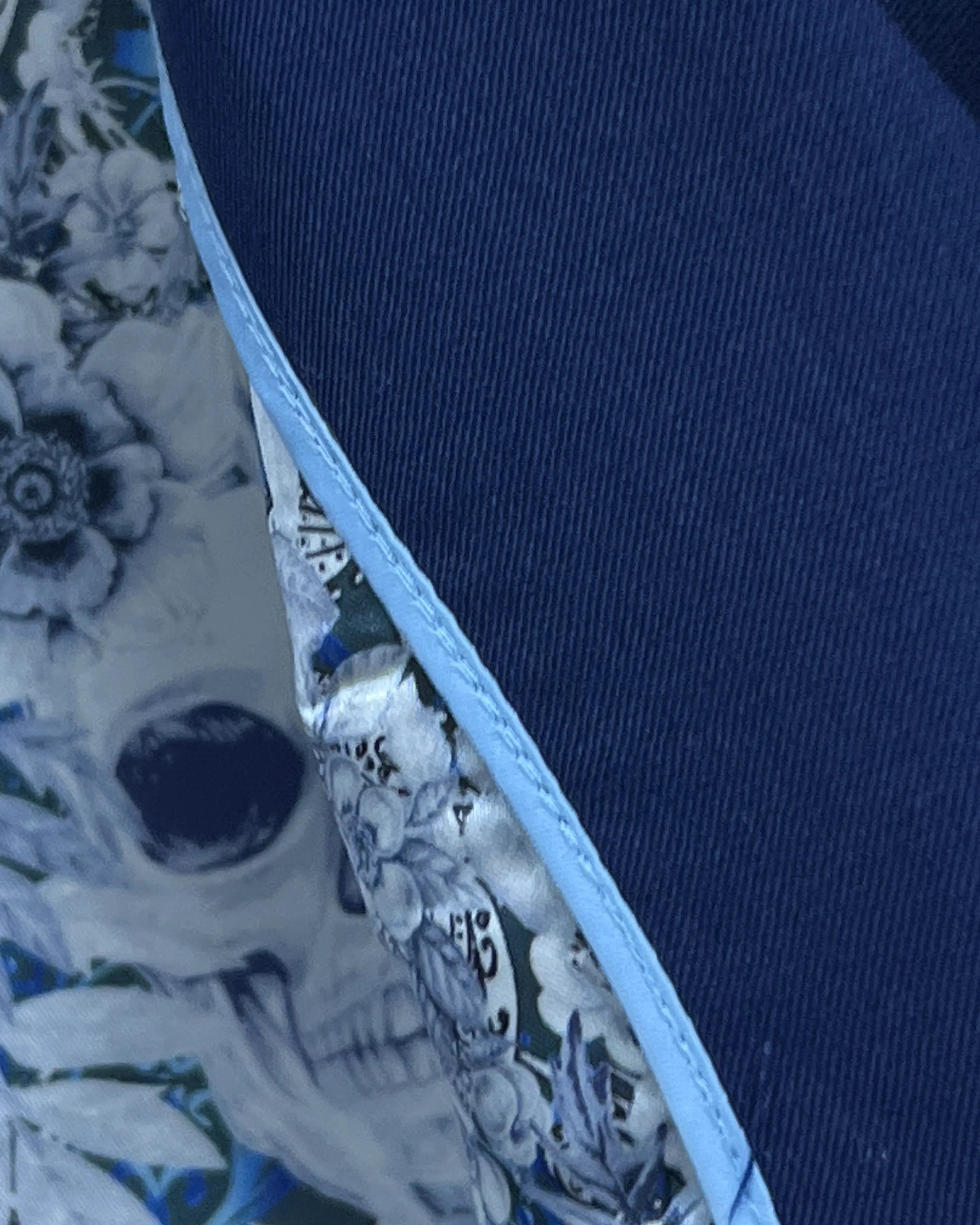 Fabric close up of royal blue sharkskin men's suit showing smooth worsted sharkskin weave and fine twill definition.