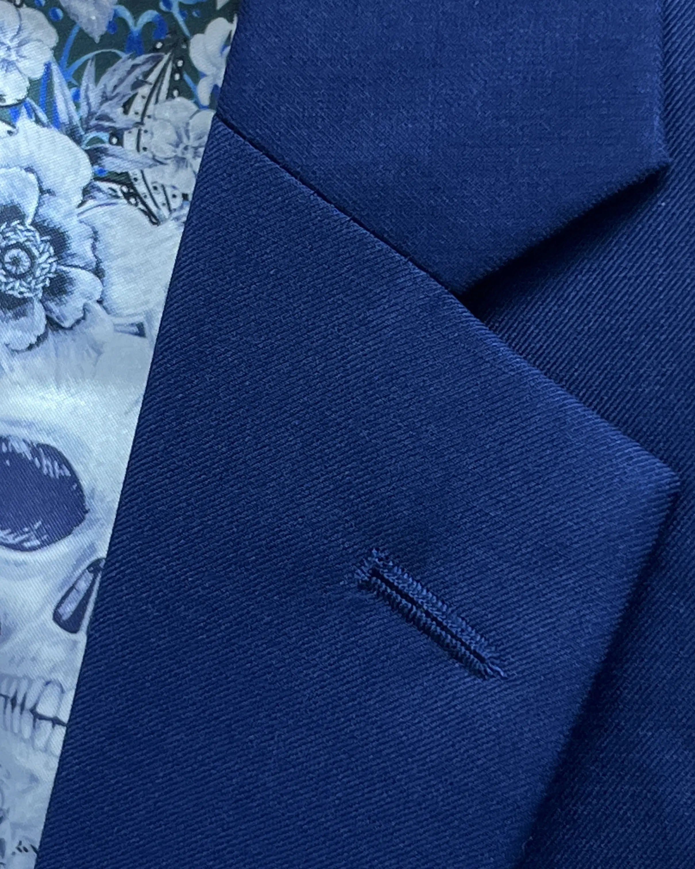 Lapel buttonhole close up of royal blue sharkskin men's suit showing standard matching stitching.