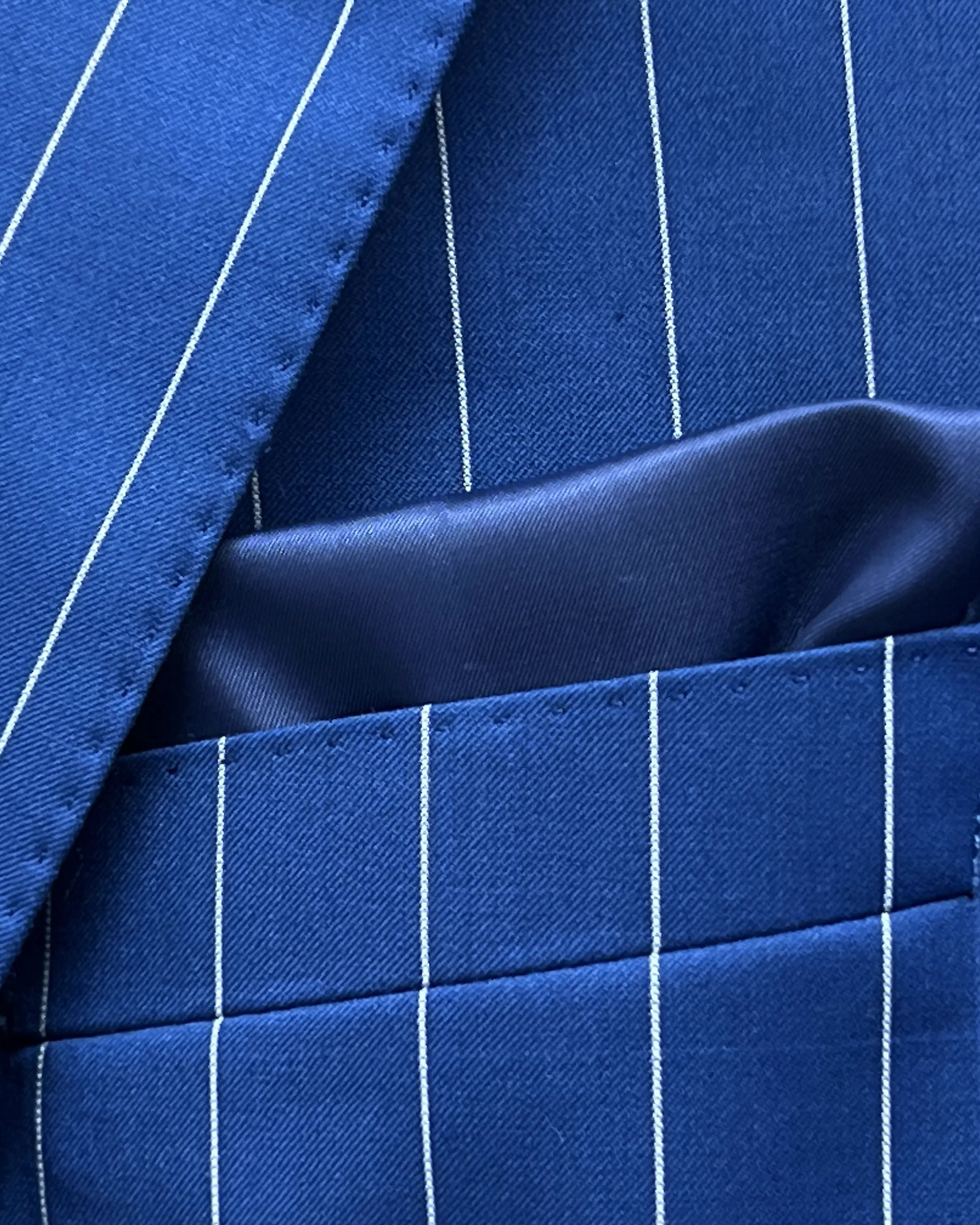Pocket square close up of royal blue white pinstripes men's suit showing built in lining pocket square