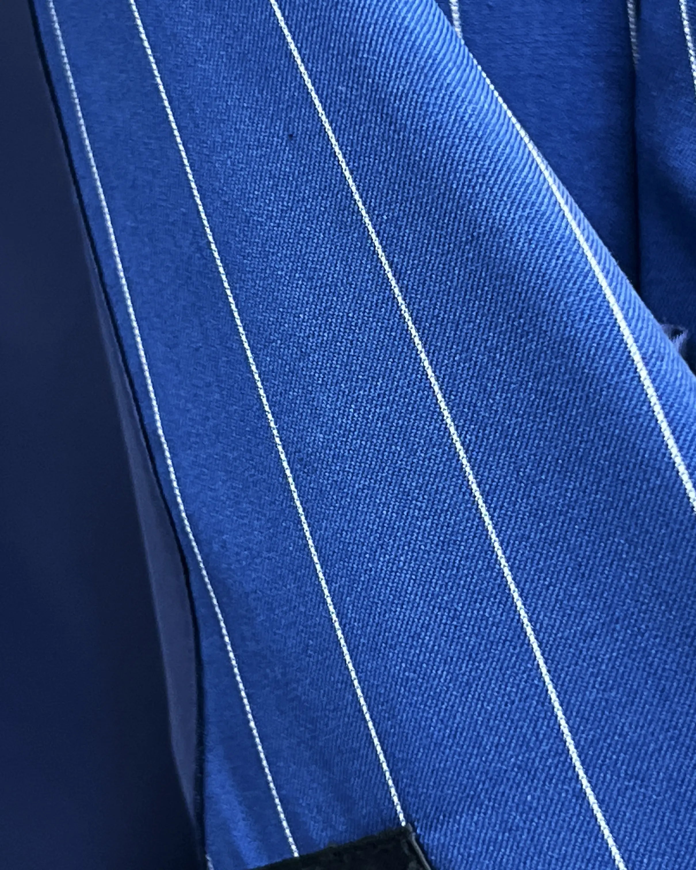 Fabric close up of royal blue white pinstripes men's suit showing cloth texture