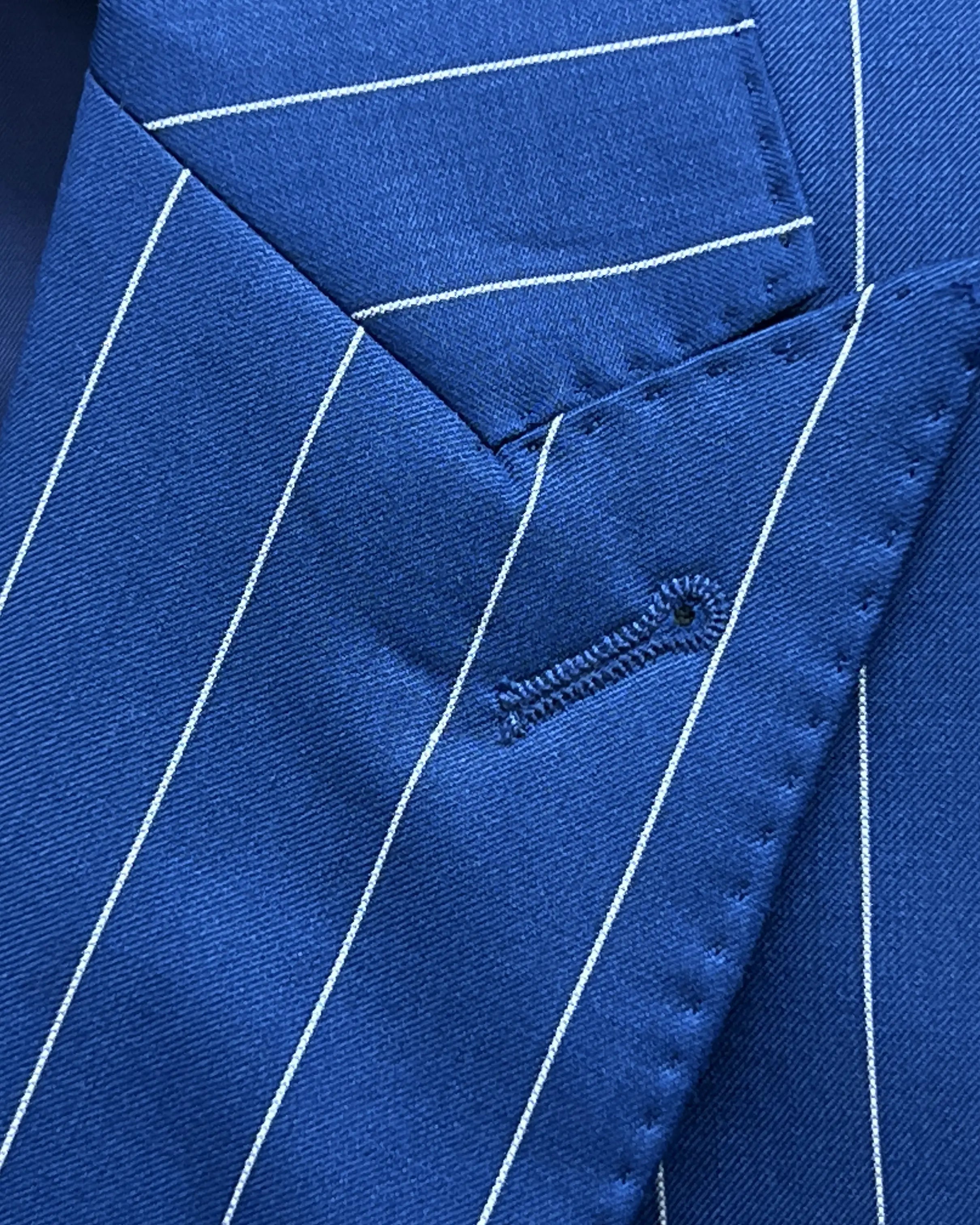 Lapel close up of royal blue white pinstripes men's suit showing standard lapel buttonhole