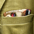 Breast pocket of tan corduroy sport coat with hand-finished edges and pick stitching detail