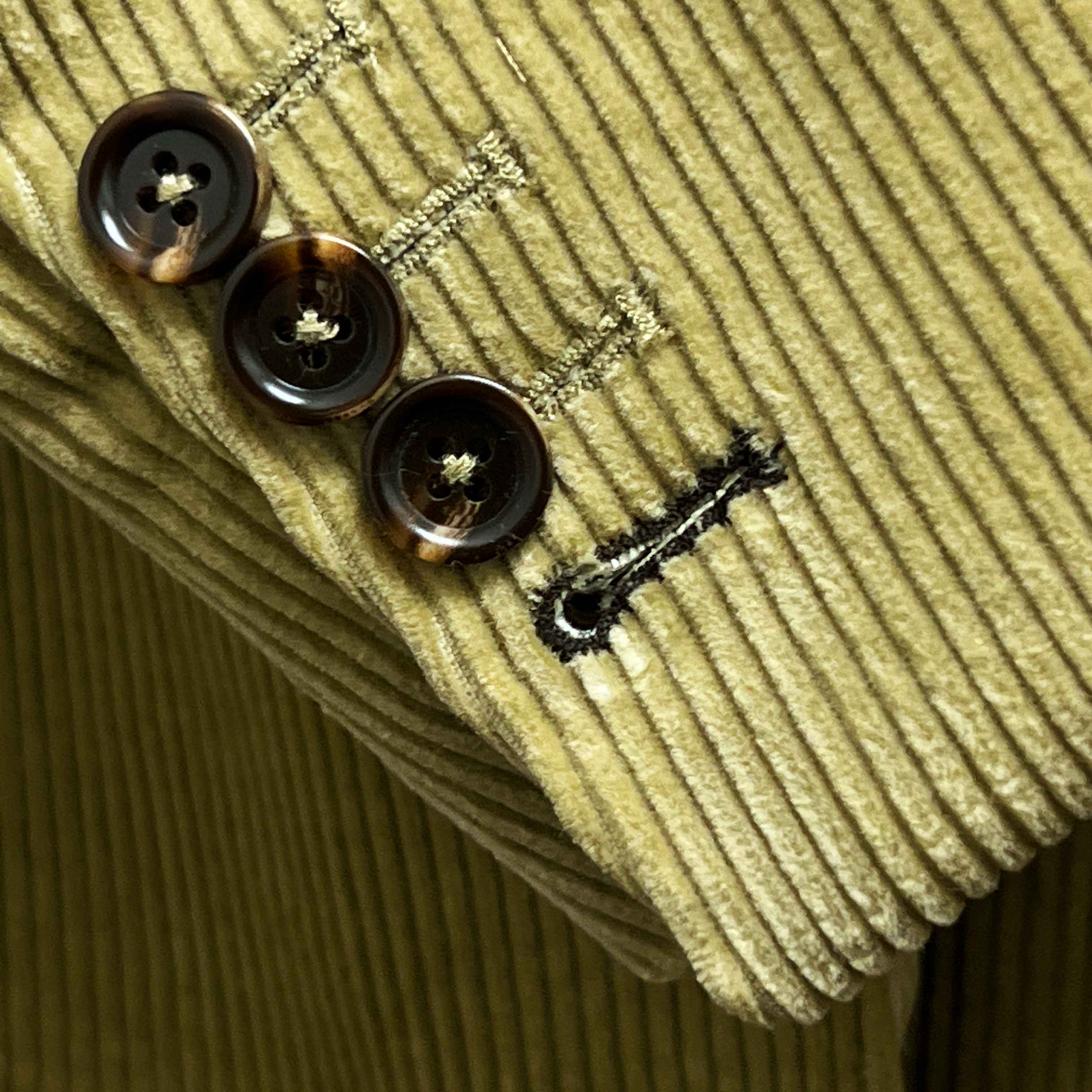 Sport coat sleeve cuff showing functional buttonholes with contrast dark brown accent stitching on tan corduroy fabric