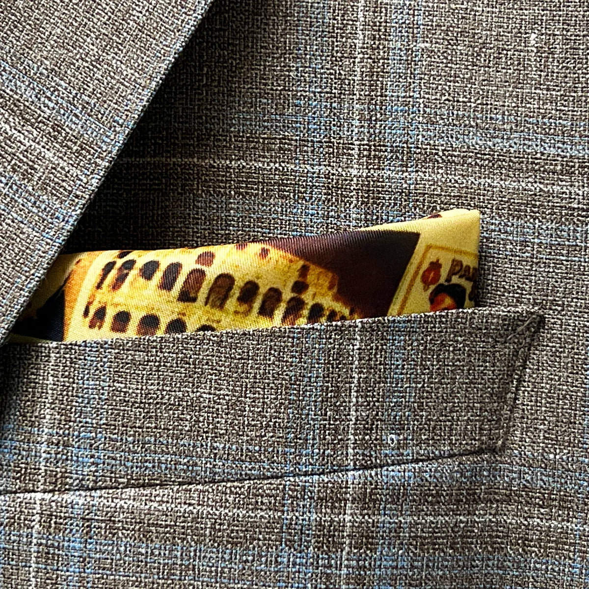 Breast pocket of tan blue windowpane sport coat with built-in pocket square holder and hand-finished edges