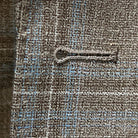 Detailed macro shot of hand-finished buttonhole stitching on tan blue windowpane sport coat with sky blue contrast thread