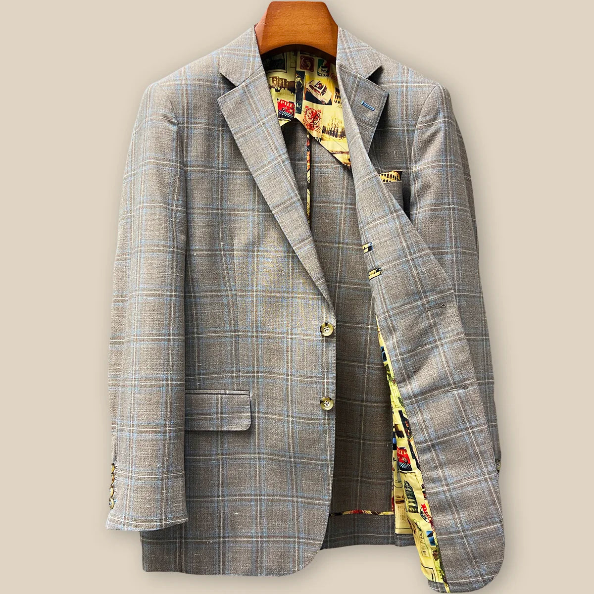 Interior left side of tan blue windowpane sport coat displaying vibrant yellow multicolored mosaic lining with inner pocket