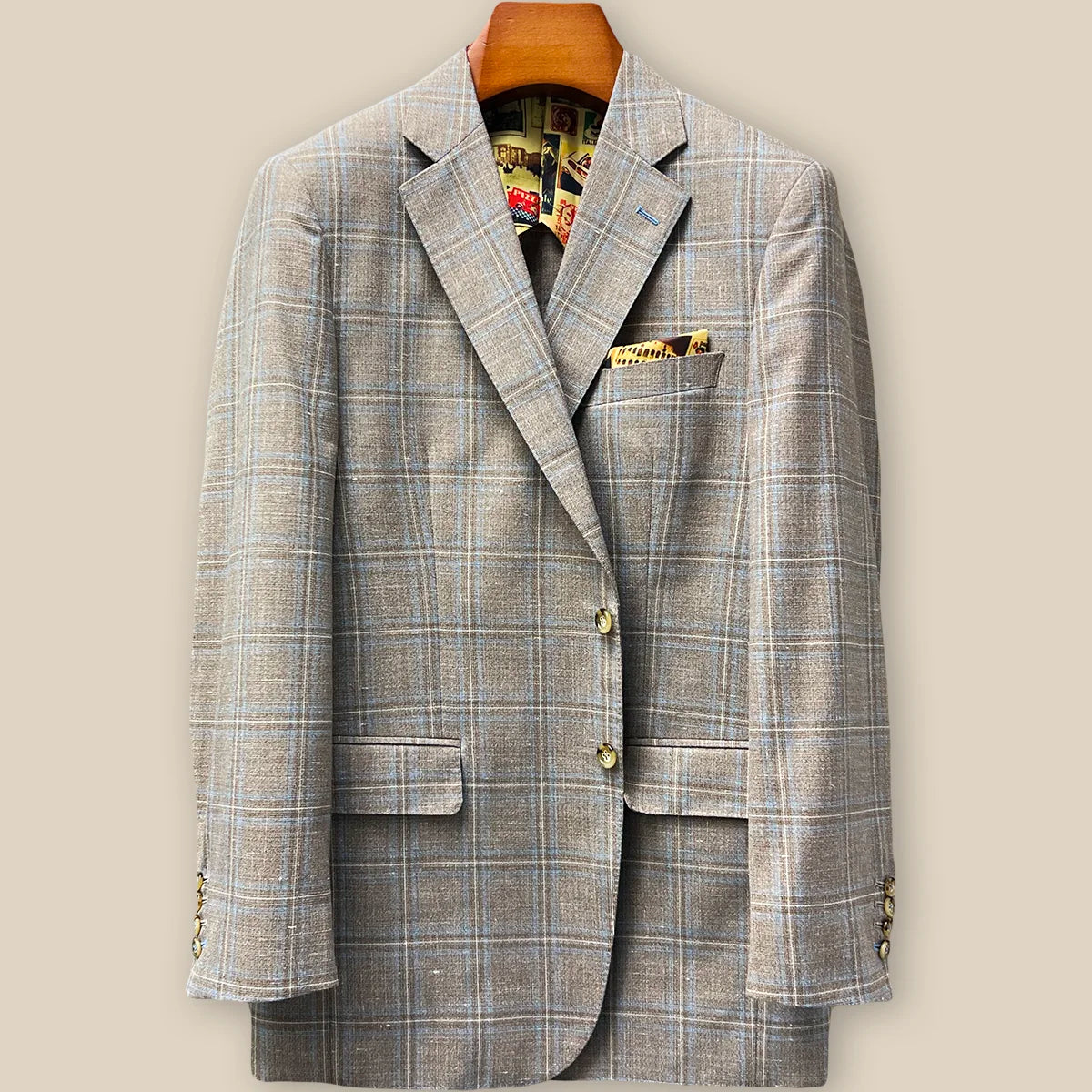 Front button panel of tan blue windowpane sport coat featuring tan and deep brown horn buttons with hand pick stitching