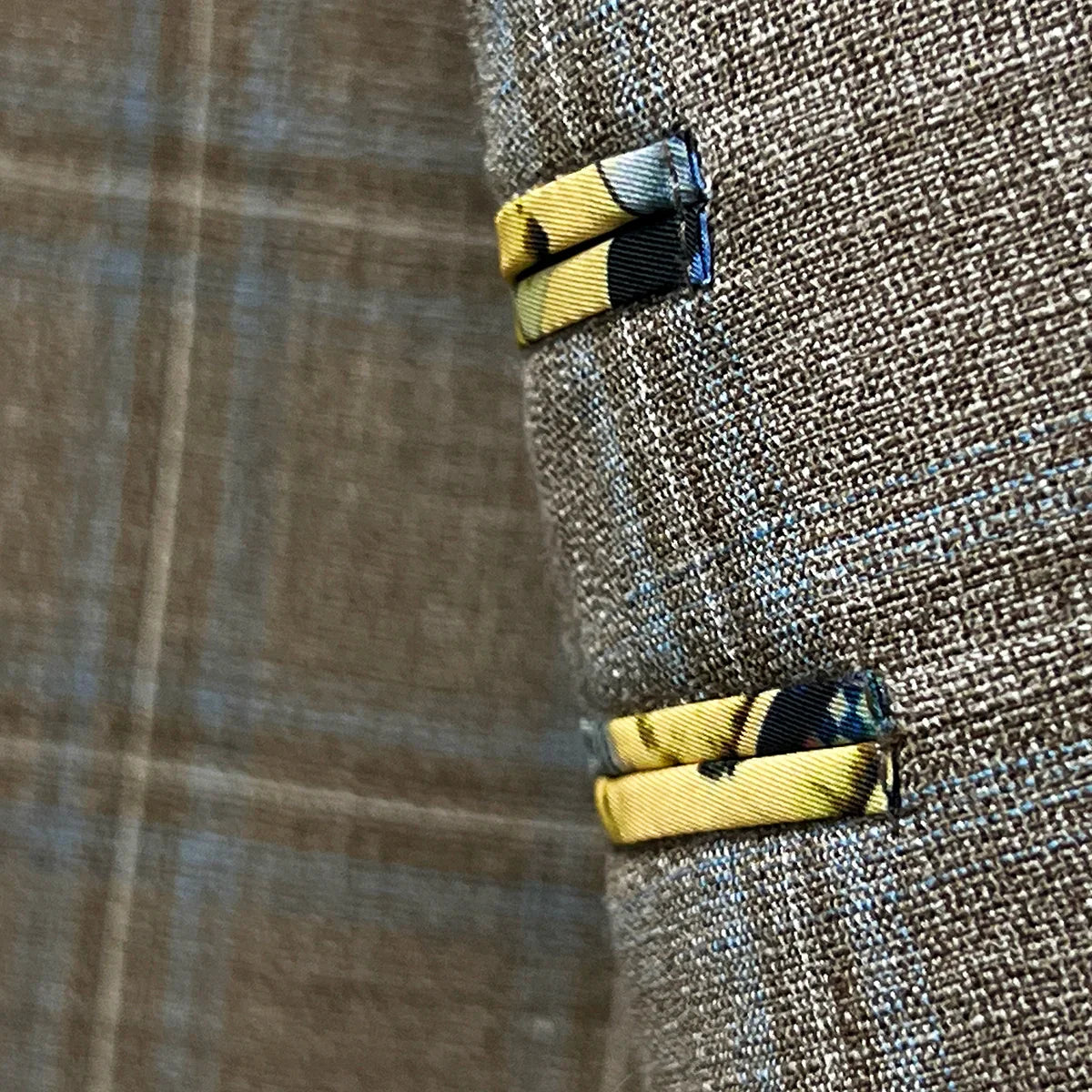 Close-up fabric detail showing tan base with blue windowpane check pattern and weave structure