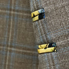 Close-up fabric detail showing tan base with blue windowpane check pattern and weave structure
