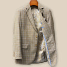 Interior left side of tan brown glen check sport coat displaying champagne gold paisley lining with inner pocket