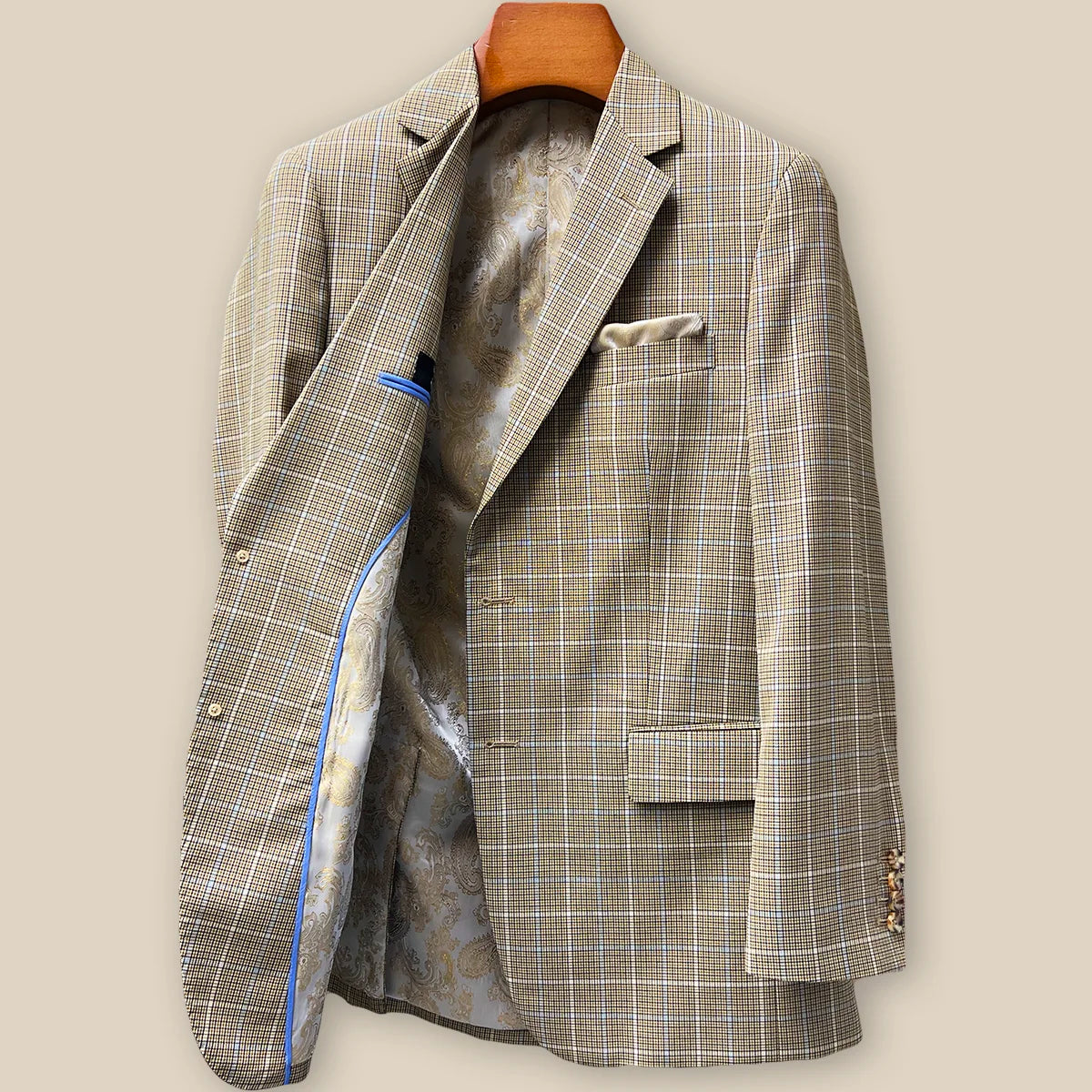 Interior right side of tan brown sport coat revealing champagne gold paisley lining and internal construction details