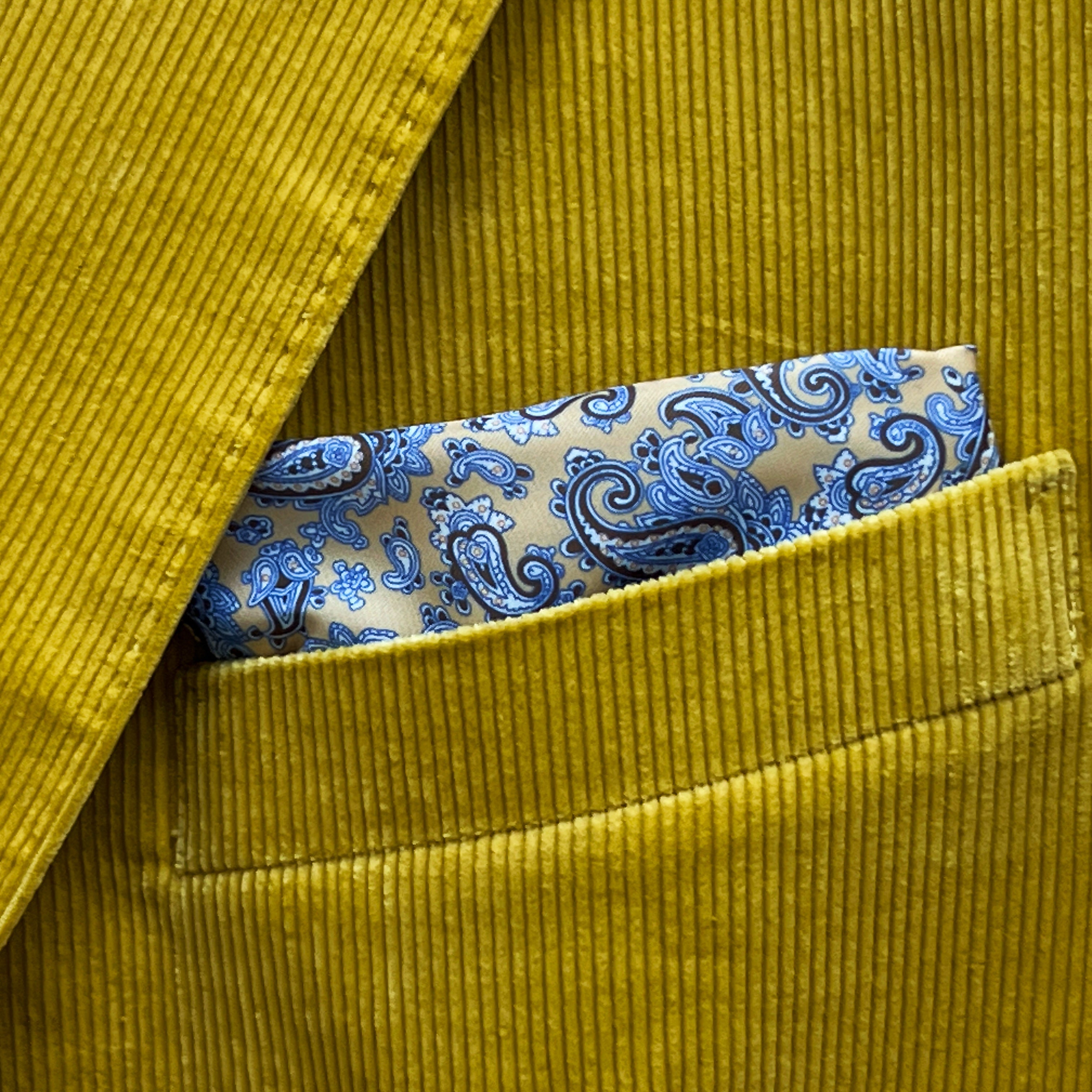 Breast pocket of warm mustard yellow corduroy sport coat with built-in pocket square holder and hand-finished edges