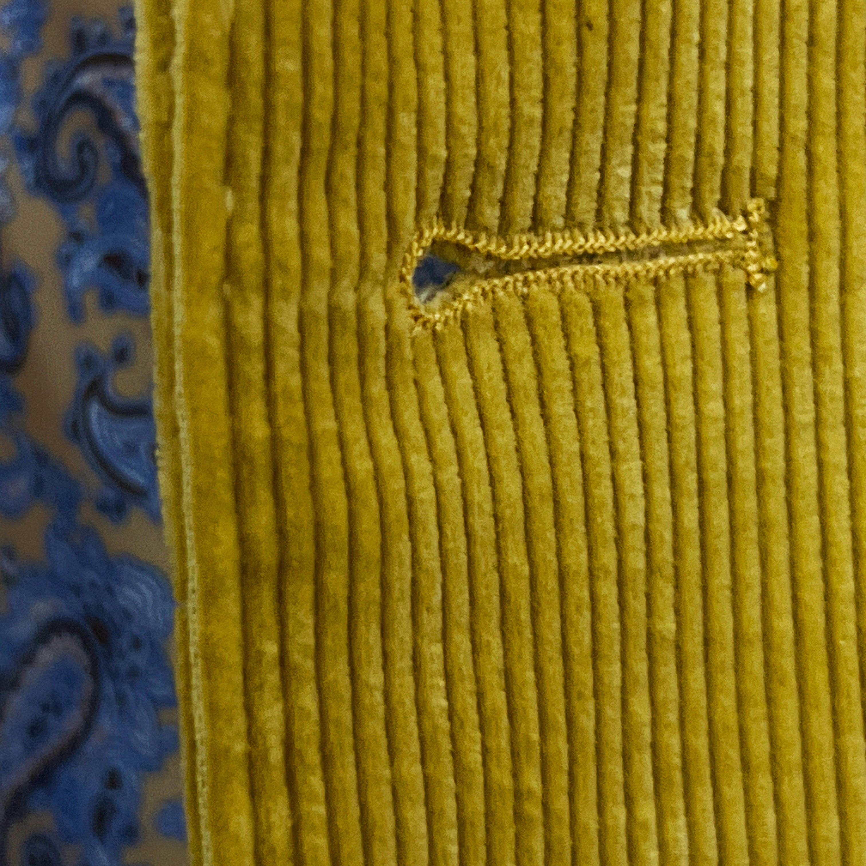 Detailed macro shot of hand-finished buttonhole stitching on warm mustard yellow corduroy sport coat with precision craftsmanship