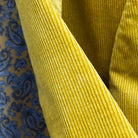 Macro view of 10 wale corduroy texture on warm mustard yellow sport coat showing distinctive ridge pattern