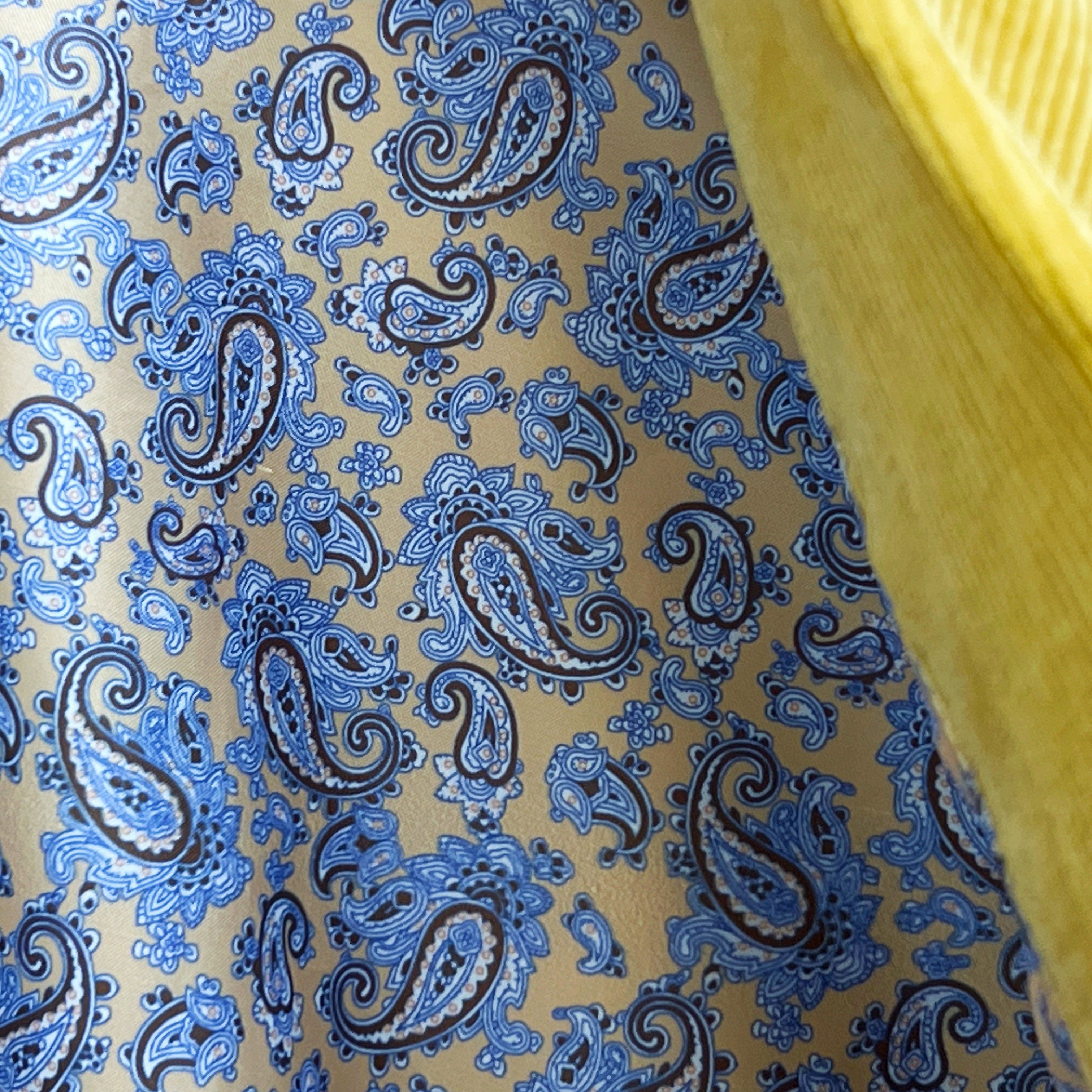 Colorful flash lining detail visible at jacket cuffs and vents in beige silk with blue paisley pattern