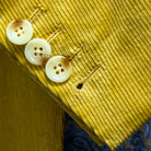 Sport coat sleeve cuff showing functional buttonholes with hand-finished stitching on warm mustard yellow corduroy fabric