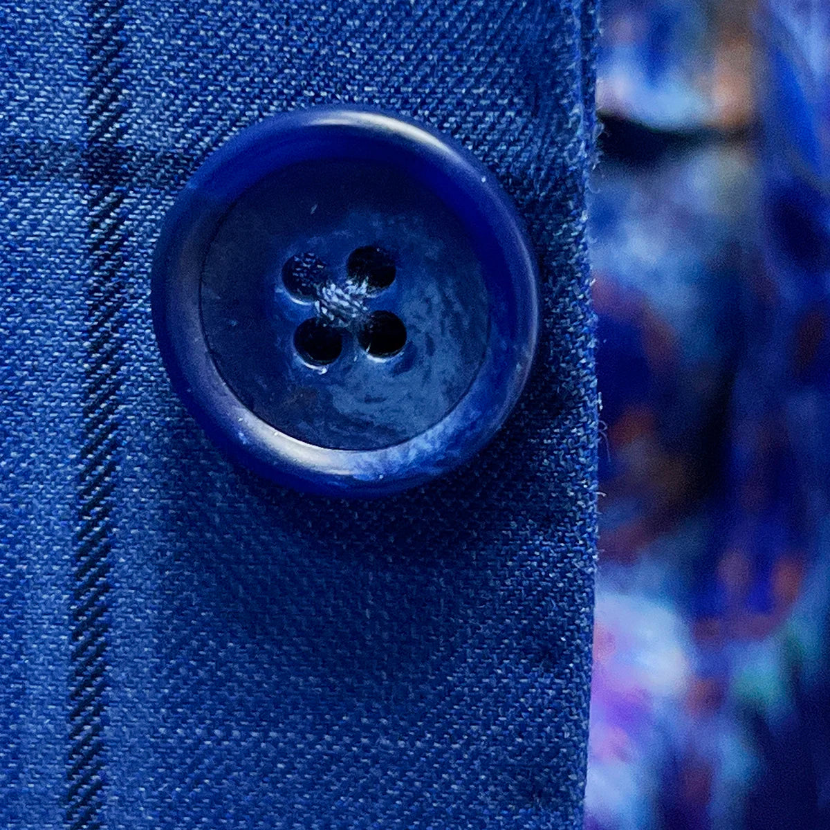 Close-up of medium blue horn buttons on royal blue windowpane suit jacket showing natural marble-like patterns
